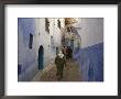 Woman Walking Through Pastel Coloured Streets Of Chefchaouen, Morocco, North Africa, Africa by Christian Kober Limited Edition Print