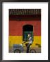 Ice Cream Vendor Riding Bicycle Past Colourful House, Granada, Nicaragua by Margie Politzer Limited Edition Print