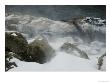 Snow Blowing Over Large Bolders On The Bank Of A River by Todd Gipstein Limited Edition Print