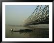 A Man Guides A Boat Under A Bridge On The Hooghly River At Calcutta by Ed George Limited Edition Print