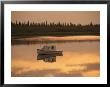 An Anchored Boat Floats On The Mackenzie River At Sunset by Raymond Gehman Limited Edition Print