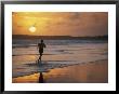 A Man Runs Through The Surf On Shella Beach At Sunset by Bobby Model Limited Edition Pricing Art Print