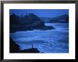 A Silhouetted Person Stands On The Rocky Coast As Night Falls by Joel Sartore Limited Edition Print