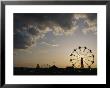A Ferris Wheel Is Silhouetted Against The Evening Sky by Stephen Alvarez Limited Edition Pricing Art Print
