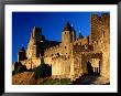 Tourists Enter Medieval Walled City At Sundown Via Porte D'aude, Carcassonne, France by Dallas Stribley Limited Edition Print