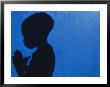 Shadow Of A Boy Praying Against A Blue Wall by Josh Mitchell Limited Edition Print