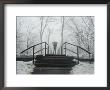 Railings Of A Small Bridge Frame A Lone Figure With An Umbrella by Stephen St. John Limited Edition Pricing Art Print