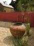 Gravel Courtyard In June With Large Terracotta Container, Red Wall, Water Spouts And Trough by Clive Nichols Limited Edition Pricing Art Print