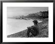 Young African American Boy Sitting On Memphis Riverbank Watching Boats On The Mississippi River by Ed Clark Limited Edition Print