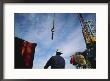 A Worker Uses A Crane And Hoist To Lift A Large Container Onto An Oil Rig by Eightfish Limited Edition Print