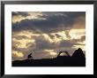 A Mountain Biker Cycles Toward Tents At A Campsite by Dugald Bremner Limited Edition Print