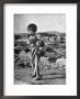 Girl Standing In Rubble From The Korean Civil War, Carrying A Baby In A Sling On Her Back by Joe Scherschel Limited Edition Print