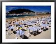 Striped Sunshades At Playa De La Concha With Mt. Urgull In Background, San Sebastian, Spain by Dallas Stribley Limited Edition Pricing Art Print