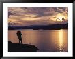 A Hiker Pauses For Reflection Alongside Lake Powell At Sunset by Gordon Wiltsie Limited Edition Print