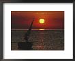 A Windsurfer Comes Near A Small Boat At Sunset by Bill Curtsinger Limited Edition Pricing Art Print