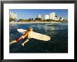 A Surfer Jumps Into The Sea With The Golden Mile In The Background, Kwazulu-Natal, South Africa by Roger De La Harpe Limited Edition Print