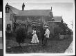 Two Men Watching As A Young Woman Plays Lawn Tennis; Other Women Watch From A Second Story Porch by Wallace G. Levison Limited Edition Print