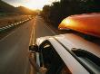 A Car With A Kayak On Top Speeds Down A Two-Lane Highway by Stephen Alvarez Limited Edition Print