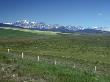 View Of The Canadian Rockies Across A Green Plain, With Fence by Stephen Sharnoff Limited Edition Print