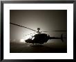 Illumination From The Bright Light Silhouettes Of Oh-58D Kiowa Helicopter During Thick Fog by Stocktrek Images Limited Edition Print
