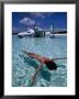 Female Floating In Crystal Waters In Front Of Seaplane, Bahamas by Greg Johnston Limited Edition Print