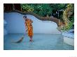 Young Buddhist Monk Sweeps Grounds At Wat Chaimong Khon Along Ping River At Sunset, Thailand by Paul Souders Limited Edition Print