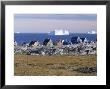 Painted Village Houses In Front Of Icebergs In Disko Bay, West Coast, Greenland by Anthony Waltham Limited Edition Print