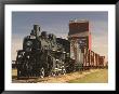 Steam Train And Grain Elevator In Western Development Museum, Saskatchewan, Canada by Walter Bibikow Limited Edition Print