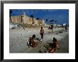 Children Playing On Beach In Front Of Restored Fort Ribat, Monastir, Tunisia by Damien Simonis Limited Edition Print