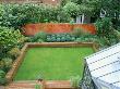 Overview Of Garden With Conservatory, Lawn Edged With Raised Brick Bed Of Box Balls And Grasses by Clive Nichols Limited Edition Print