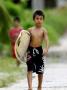 Young Local Boy Heading Out For Afternoon Surf, Lagundri Bay, Pulau Nias, North Sumatra, Indonesia by Paul Kennedy Limited Edition Pricing Art Print