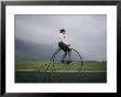 A Man Pedals An Old-Fashioned Bicycle Ahead Of An Indiana Thunderstorm by Melissa Farlow Limited Edition Pricing Art Print