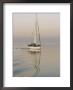 Motoring Sailboat On Glassy Waters At Dusk by Rich Reid Limited Edition Print