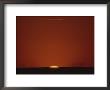 A Contrast Shot Of Red Sky And Dark Horizon, With A Setting Sun by Kenneth Garrett Limited Edition Print