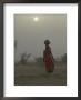 Woman Carrying Water Jar In Sand Storm, Thar Desert, Rajasthan, India by Keren Su Limited Edition Print