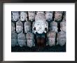 A Shy Young Boy Hiding Behind One Of Many Carved Wooden Faces In A Shop Front, Indonesia by Adams Gregory Limited Edition Pricing Art Print