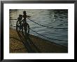 Bicycle Resting On A Railing Along Victoria Harbour As The Sun Sets by Todd Gipstein Limited Edition Pricing Art Print