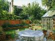 View Across Modernists Town Garden With Metal Garden Furniture And Conservatory In The Foreground by Clive Nichols Limited Edition Print