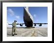 A Soldier Waits For His C-17 Globemaster Iii To Launch On An Upcoming Airdrop Mission by Stocktrek Images Limited Edition Print