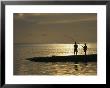 Two Fishermen Silhouetted Against The Pacific Ocean Fishing At Sunset by Todd Gipstein Limited Edition Print