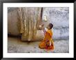 Novice Buddhist Monk Kneeling Beneath The Phra Atchana Buddha Statue, Sukhothai Province, Thailand by Gavin Hellier Limited Edition Print