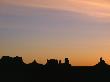 Sunset Silhouettes The Jagged Buttes And Ridges Of Monument Valley by Stephen St. John Limited Edition Print