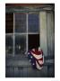 An American Flag Lies Loosely Bunched In An Open Window by Raul Touzon Limited Edition Print
