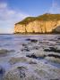 Smooth Polished Rocks On The Shore At Thornwick Bay, Looking Towards The Golden Cliffs Of Flamborou by Lizzie Shepherd Limited Edition Pricing Art Print