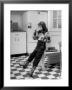 Young Girl Wearing Cowgirl Outfit Drinking Milk And Eating Sandwich In Kitchen by Nina Leen Limited Edition Print