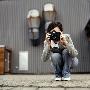 A Young Woman Crouching And Taking A Photograph by Jewgeni Roppel Limited Edition Print