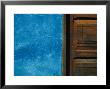 Blue Wall Stands In Stark Contrast To An Old Wooden Door by David Evans Limited Edition Print