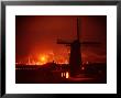 Lights And Fires Of Pernis Refinery Glowing Behind Silhouetted Windmill by Ralph Crane Limited Edition Print
