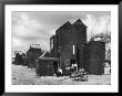 Clustered On The Shingle Of The Old Town Of Hastings Sussex Are These Tall Black Huts by Fred Musto Limited Edition Print