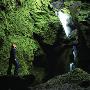 A Person Standing By Mossy Rocks And Looking At A Waterfall, Iceland by Thorsten Henn Limited Edition Print